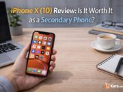 iPhone X (10) Review: Is It Worth It as a Secondary Phone? Person holding an iPhone X smartphone on a modern desk workspace with laptop and coffee cup while reviewing the phone as a secondary device.